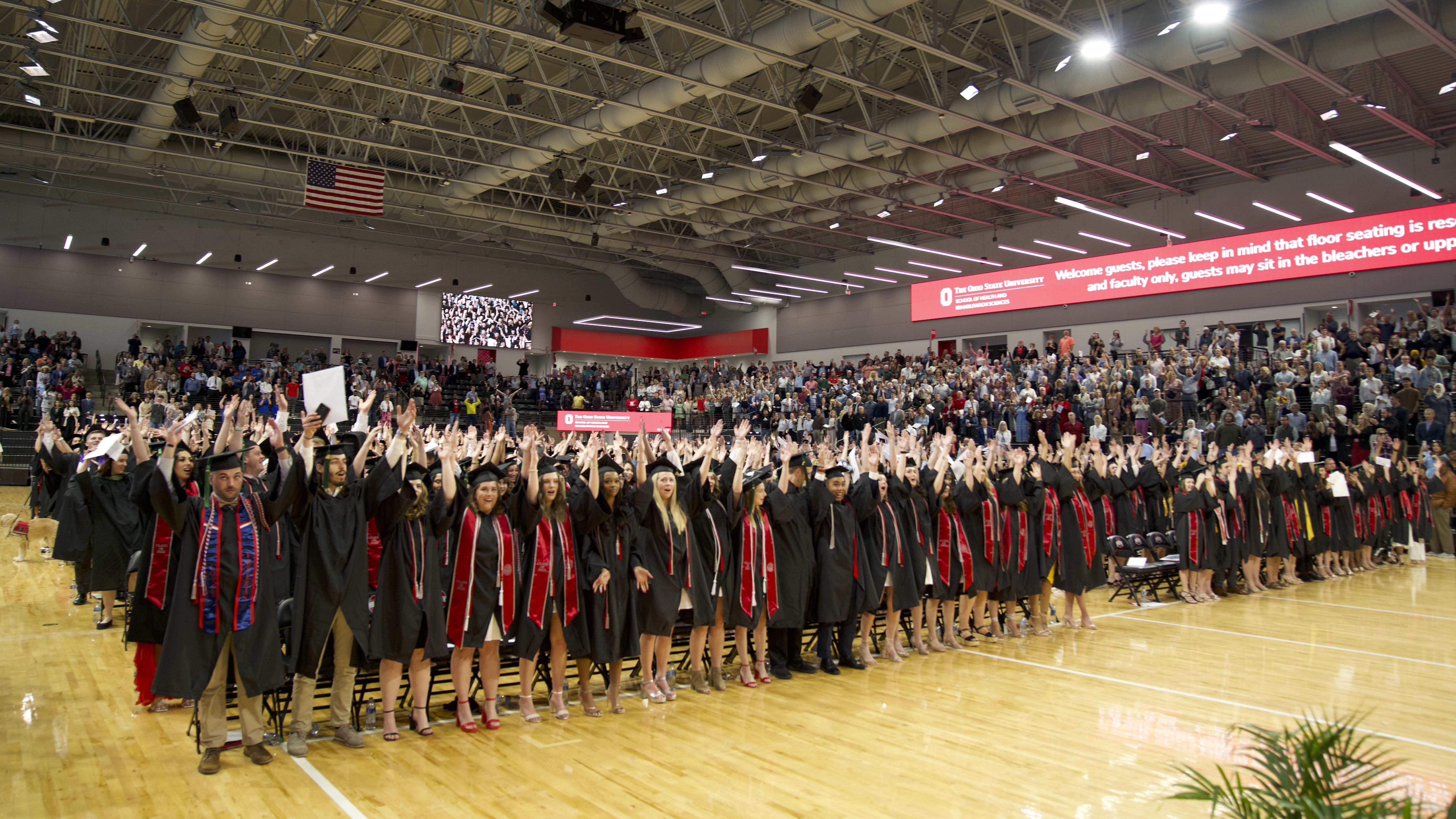 HRS Graduates in caps and gowns standing in the Covelli Center