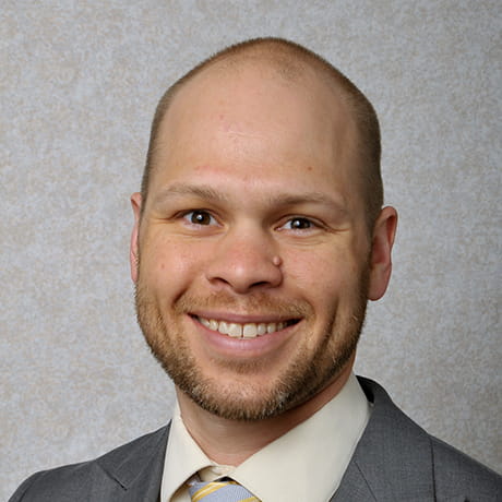 Headshot of Matt smiling wearing gray tux