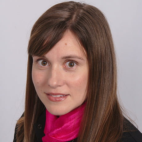 Headshot of Jill smiling wearing black shirt and pink scarf 
