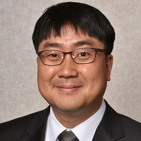 Headshot of YunSeok smiling wearing black tux