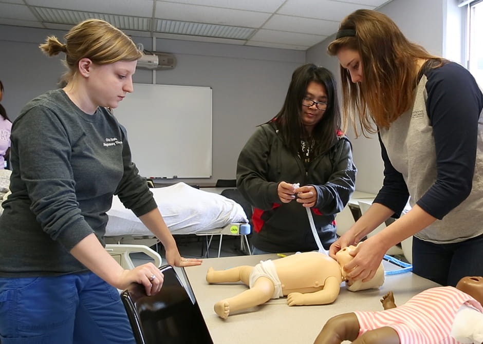 students preforming physical test on baby dummies 