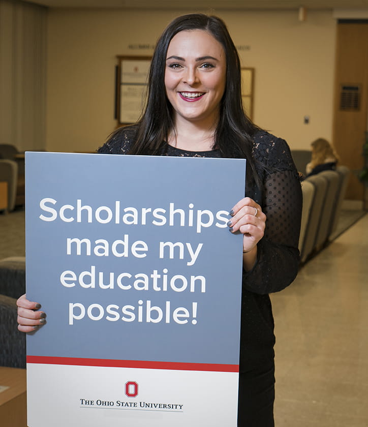 Rachael Bican  holding a scholarships made education possible poster 