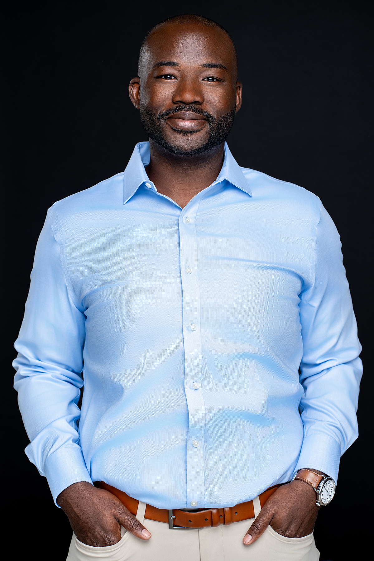 Anton Johnson posing wearing a blue dress shirt