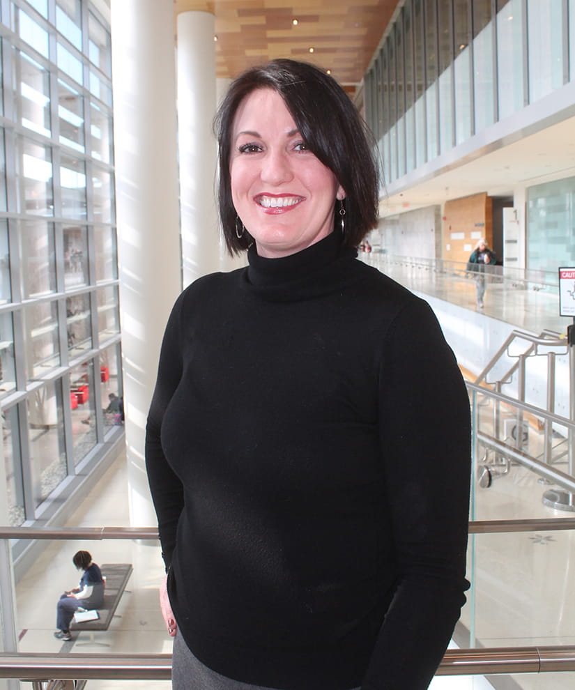 Mindy Conklin wearing a black shirt standing in a hospital atrium