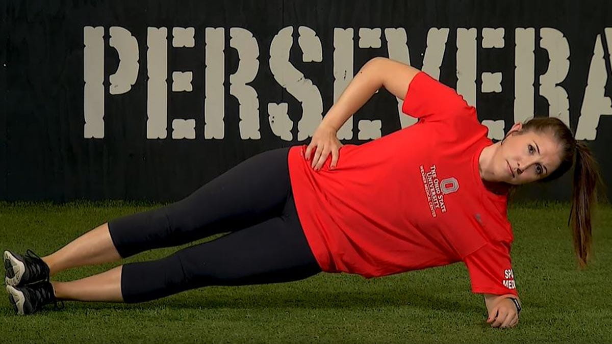woman demonstrating how to do a side plank exercise to improve abdominal core health