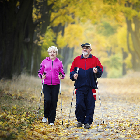Man and woman walking with poles in autumn landscape