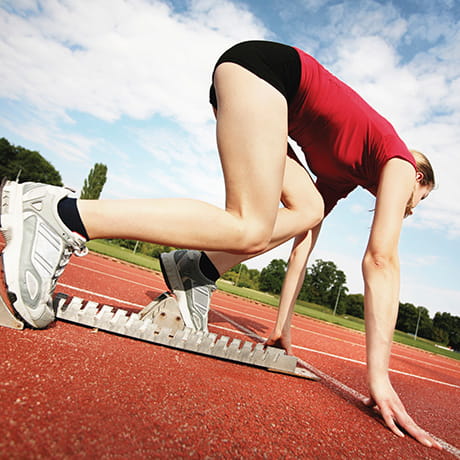 A female runner in a starting block